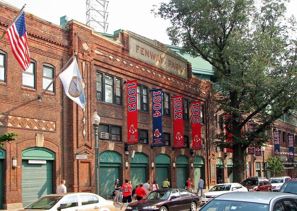 The brick front of Fenway Park on Yawkey Way, hung with championship banners