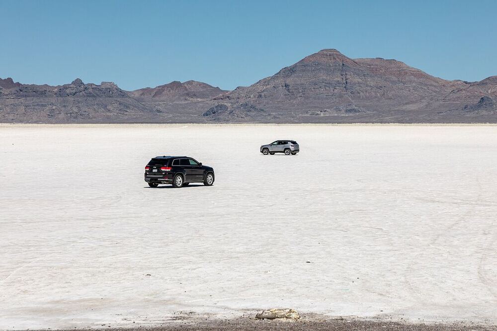 Two cars parked on the white expanse of the Bonneville Salt Flats