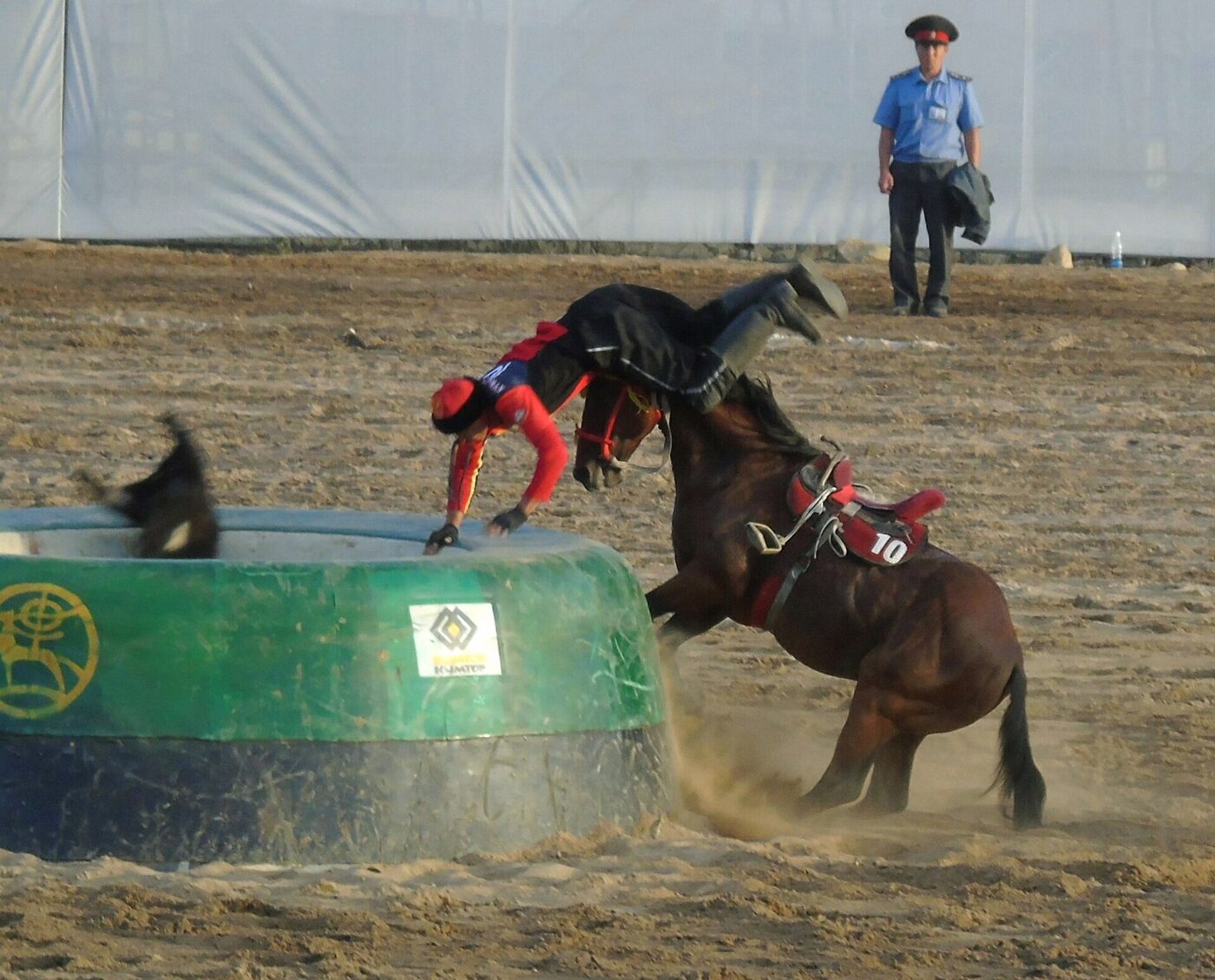 A kok-boru rider pitched over the rim of the tai kazan as the goat carcass drops in